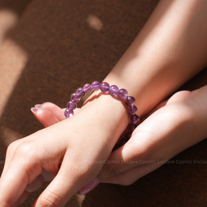 Purple Amethyst beaded bracelet on a wrist with a blurred background