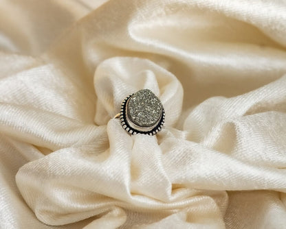  a ring with a large, square-shaped pyrite stone set in a gold-colored mounting.