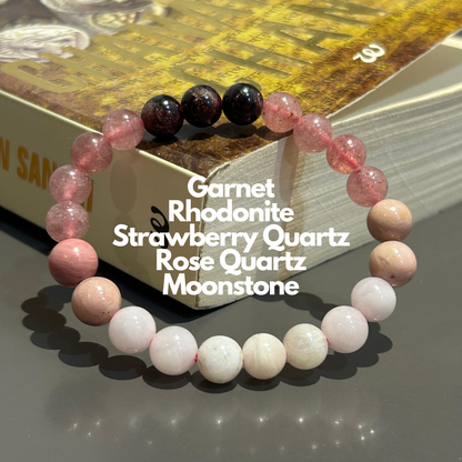 A bracelet composed of round beads in shades of pink, black, and white. Known for attracting Love in life.
